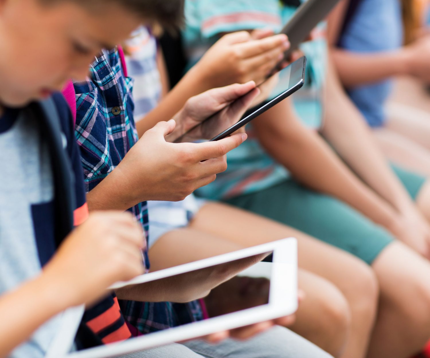 primary education, childhood, technology and people concept - close up of elementary school students with backpacks and tablet pc computers